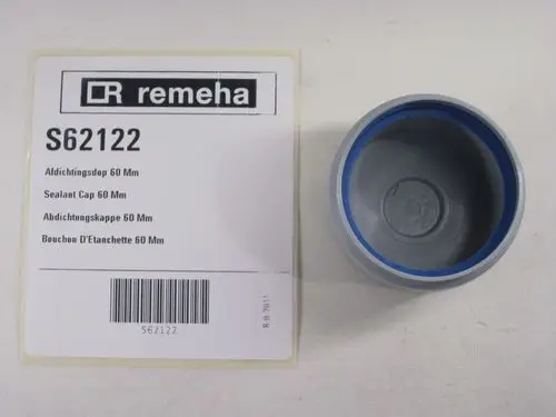 Graue Abdichtungskappe von Remeha mit blauer Dichtungslippe, liegend neben einer Produktkarte mit Artikelnummer und Beschreibung in mehreren Sprachen.